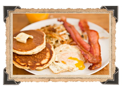 breakfast plate with eggs, hash browns, bacon, and pancakes